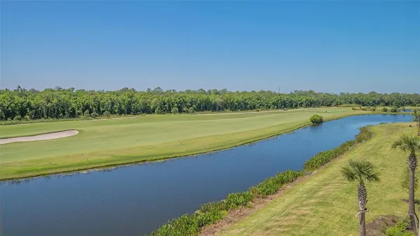 a front view of multi story residential apartment building with yard and outdoor seating