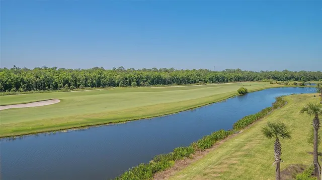 a front view of multi story residential apartment building with yard and outdoor seating