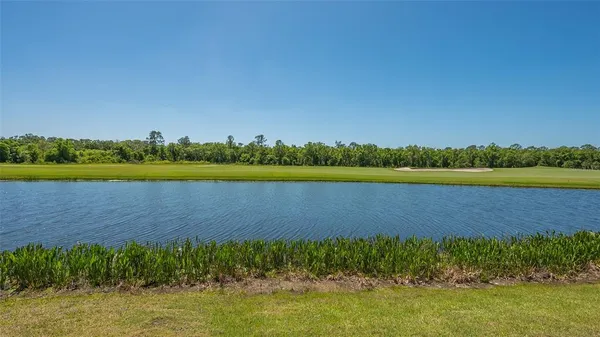 an aerial view of a swimming pool with a yard and outdoor seating