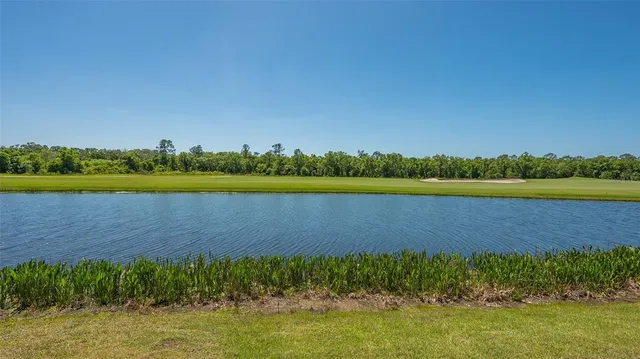 an aerial view of a swimming pool with a yard and outdoor seating