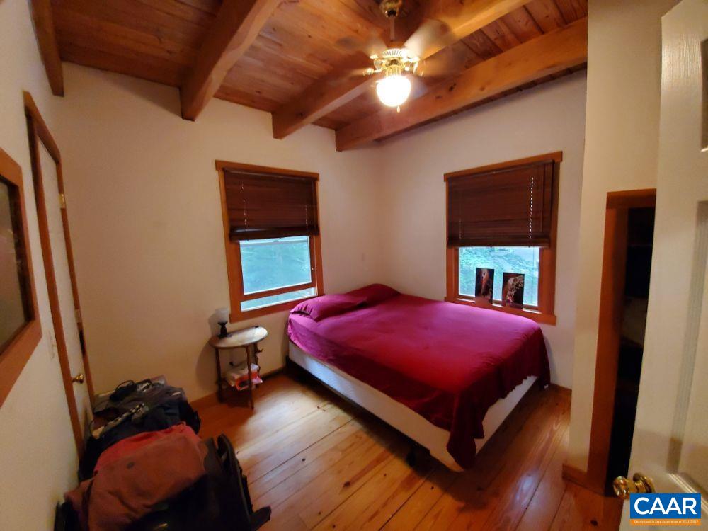 1108 Berry Hill Road Nellysford, VA 22958 - Photo 6 of 32 a bed sitting in a bedroom next to a window