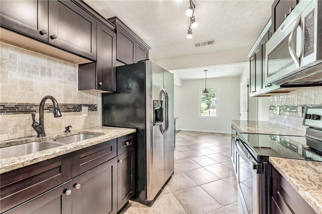 2106 East Drive Decatur, GA 30032 - Photo 1 of 1 a kitchen with stainless steel appliances granite countertop a sink stove and refrigerator