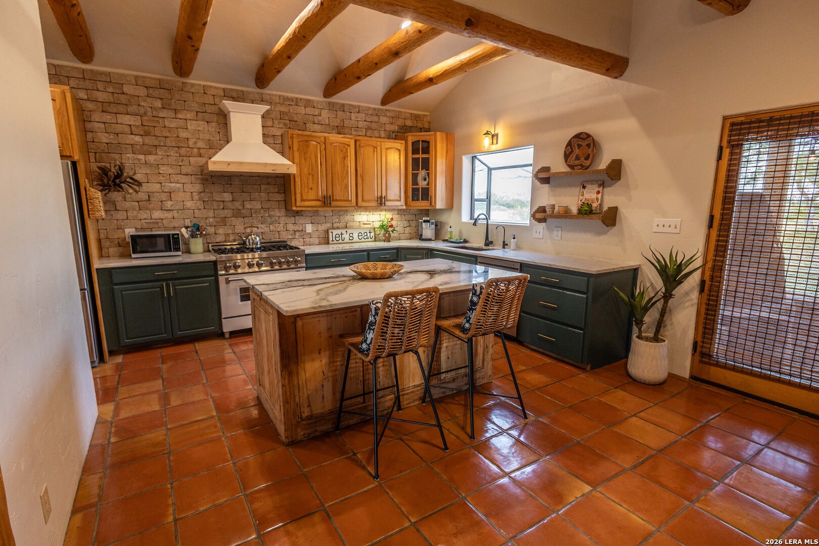 5499 Agape Road Uvalde, TX 78801 - Photo 15 of 54 a kitchen with stainless steel appliances a sink a stove a refrigerator cabinets and dining table