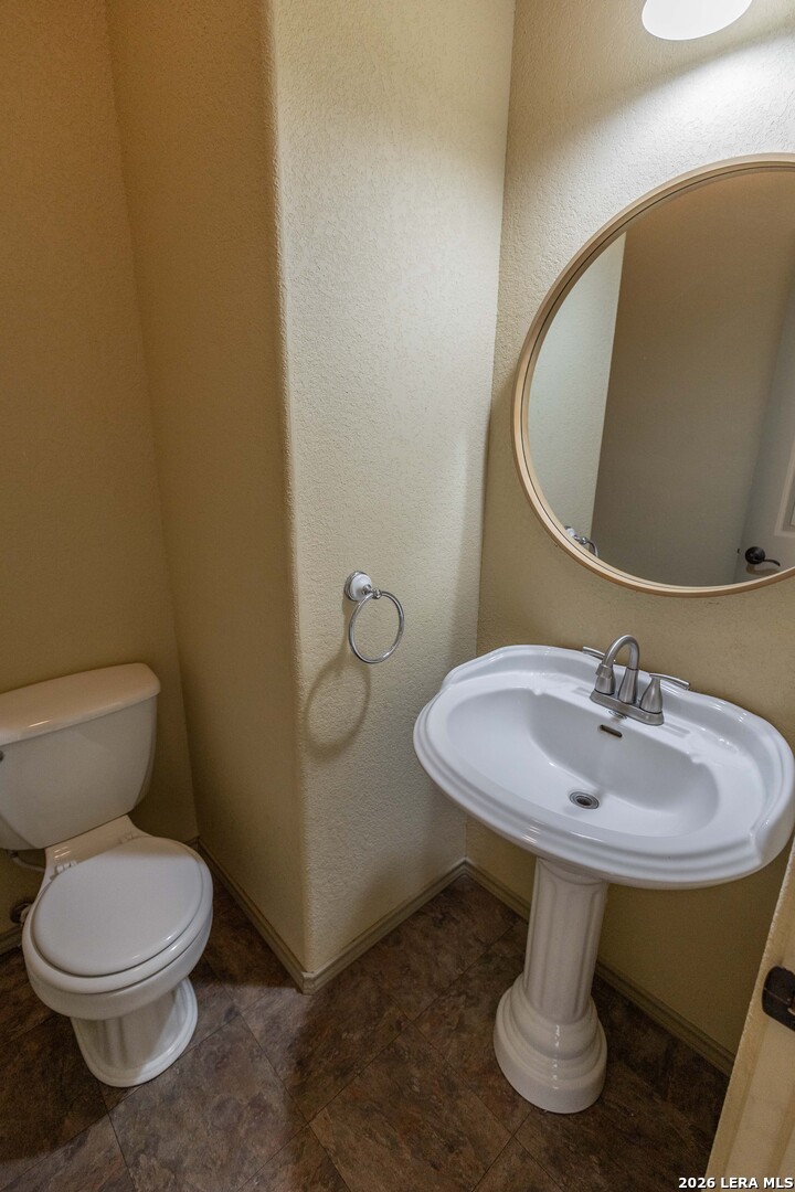 5499 Agape Road Uvalde, TX 78801 - Photo 23 of 54 a bathroom with a toilet sink and mirror