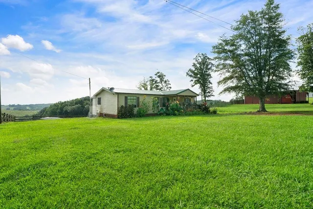 a view of a green field with wooden fence
