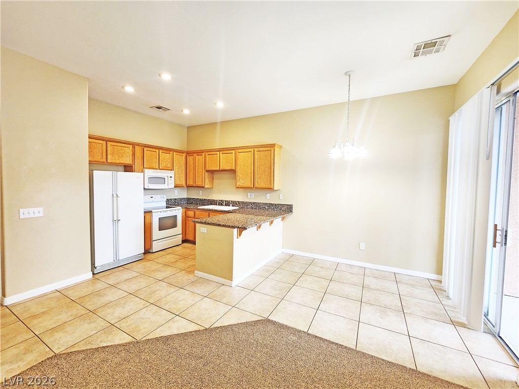 1421 Star Road, Unit 2 Pahrump, NV 89048 - Photo 6 of 33 Kitchen featuring a peninsula, white appliances, a chandelier, and visible vents