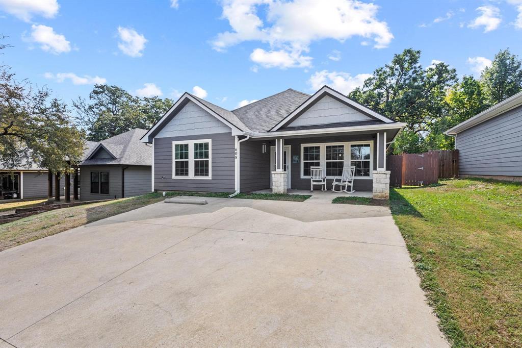 608 East Shepherd Street Denison, TX 75021 - Photo 1 of 31 Modern ranch-style residence featuring a prominent front porch, a concrete driveway, and gray siding with white trim