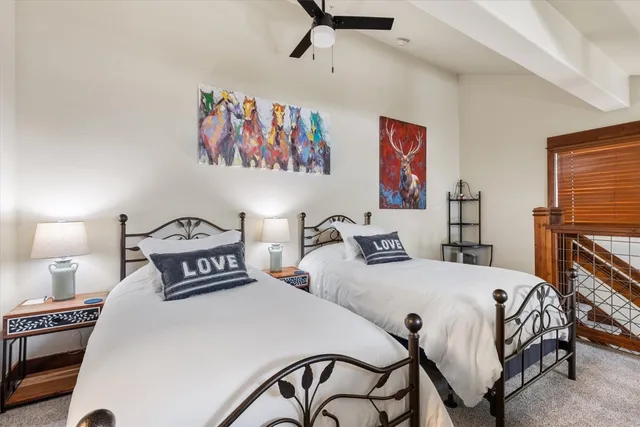 a bedroom with two beds and painting on the wall