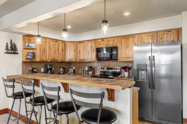 a kitchen with granite countertop a center island a refrigerator cabinets and a counter top space