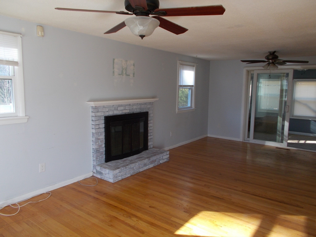 146 South Meadow Road Carver, MA 02330 - Photo 4 of 15 a view of an empty room with a fireplace and a window