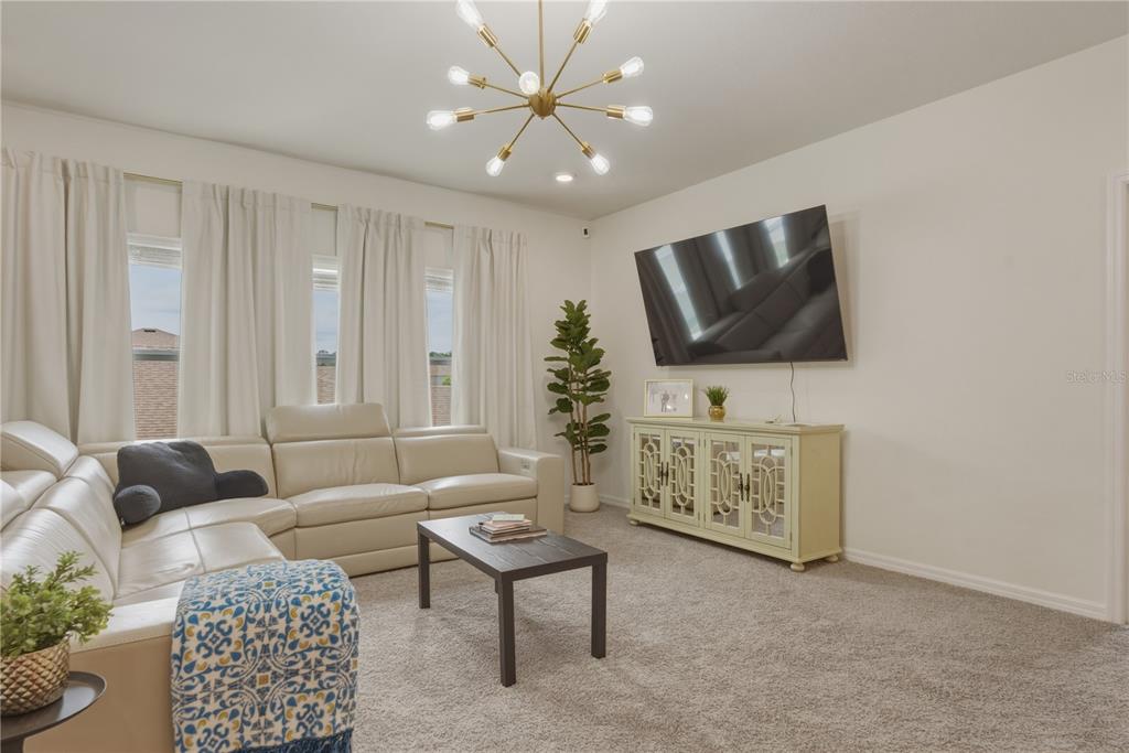 17664 Northwest 173rd Road Alachua, FL 32615 - Photo 22 of 31 a living room with furniture and a flat screen tv