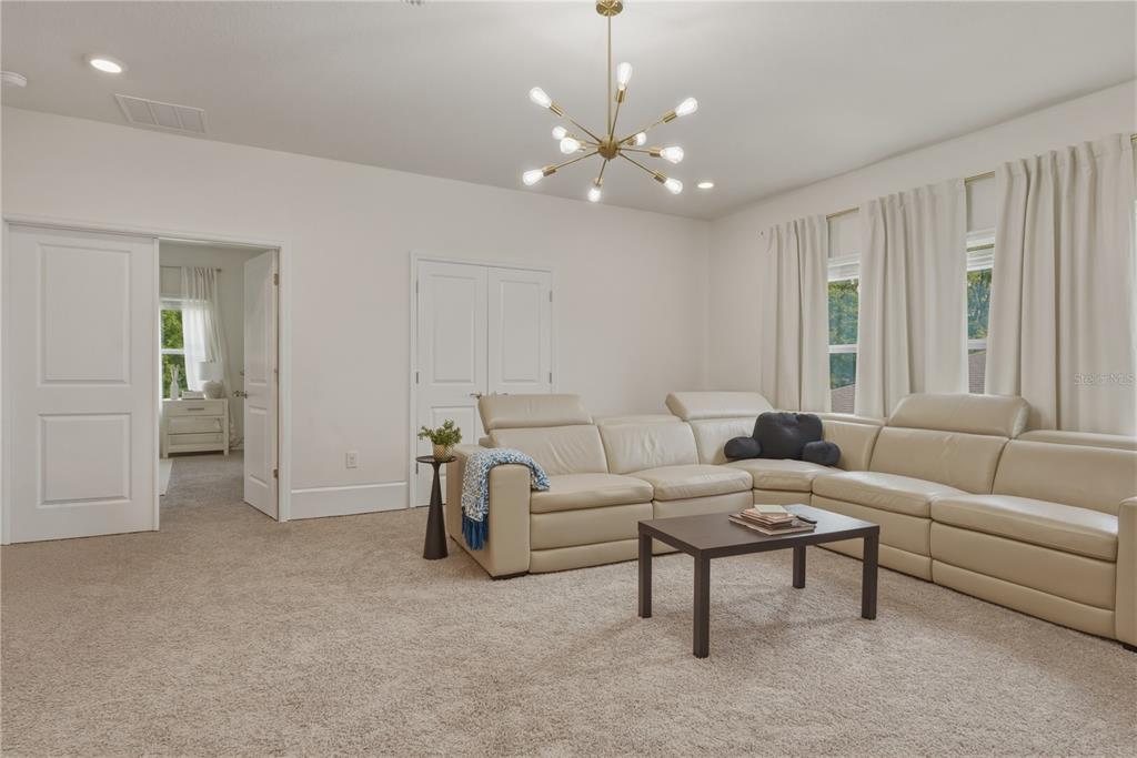 17664 Northwest 173rd Road Alachua, FL 32615 - Photo 23 of 31 a living room with furniture and a chandelier
