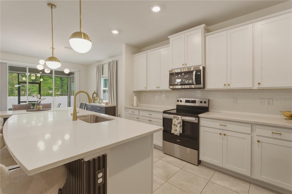 17664 Northwest 173rd Road Alachua, FL 32615 - Photo 4 of 31 a kitchen with stainless steel appliances granite countertop a sink a stove and cabinets