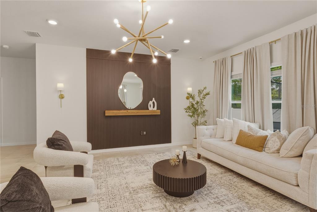 17664 Northwest 173rd Road Alachua, FL 32615 - Photo 8 of 31 a living room with furniture a chandelier and a large mirror