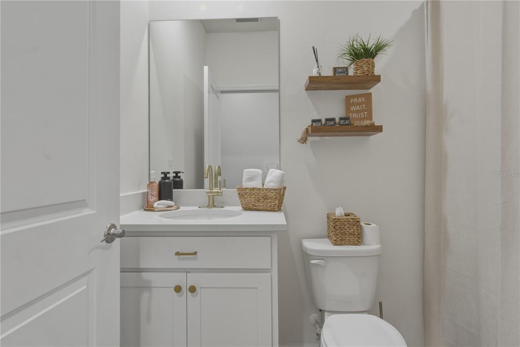 17664 Northwest 173rd Road Alachua, FL 32615 - Photo 10 of 31 a bathroom with a toilet sink vanity and mirror