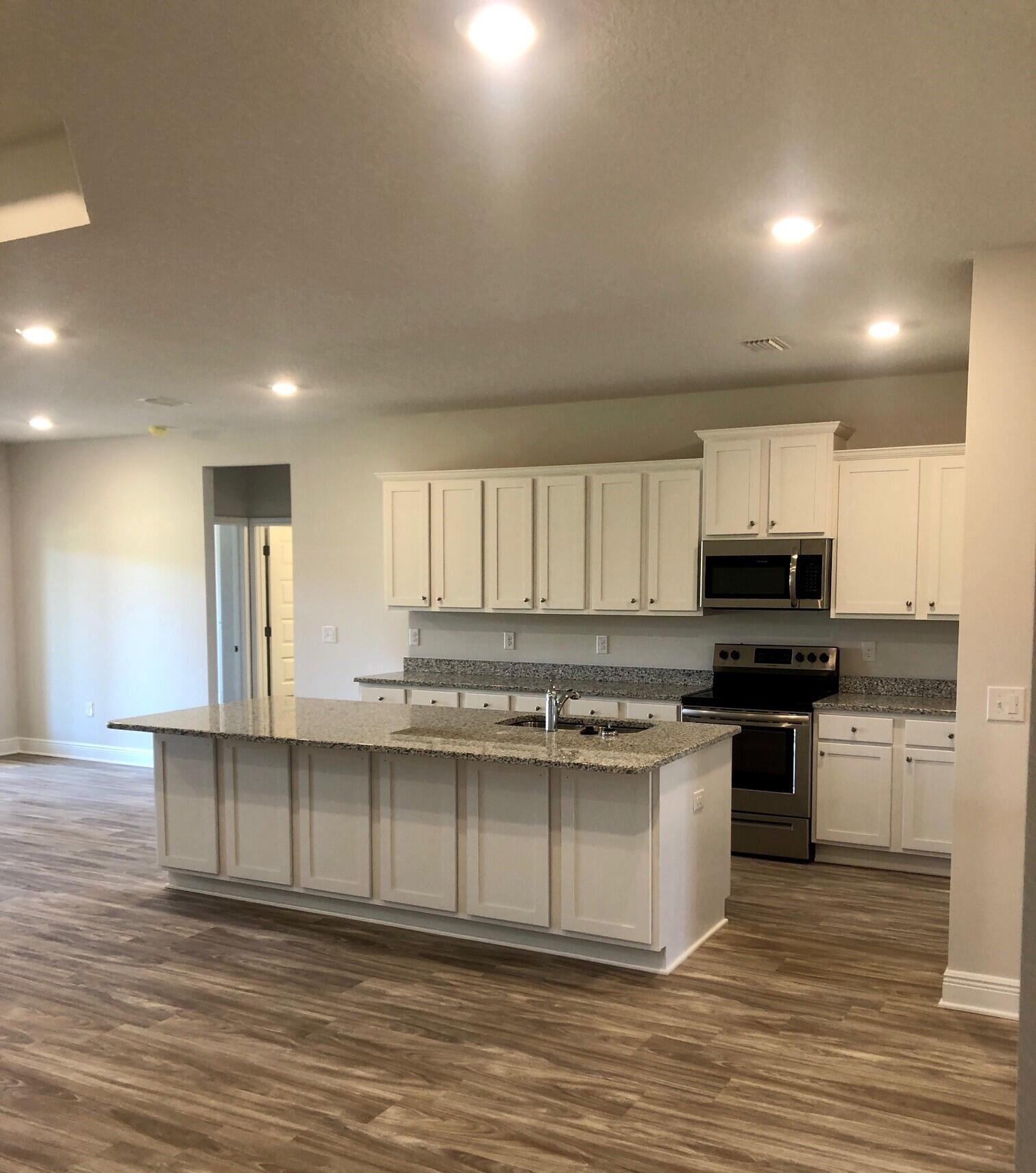 2412 Dakota Way Crestview, FL 32536 - Photo 6 of 30 a kitchen with stainless steel appliances granite countertop a stove a sink and a microwave