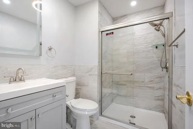 a bathroom with a shower sink vanity and toilet