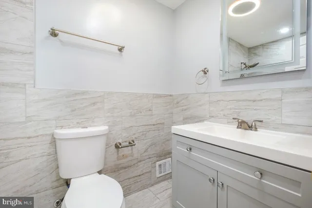 a bathroom with a sink a toilet and a mirror