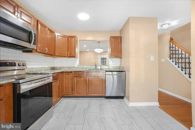 a kitchen with stainless steel appliances granite countertop a stove a sink and a refrigerator