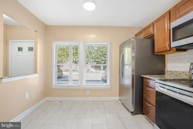 a view of kitchen with wooden floor electronic appliances and windows