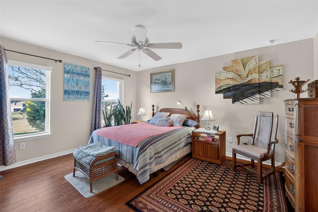 12193 Southeast 175th Loop Summerfield, FL 34491 - Photo 21 of 34 a bedroom with a bed and a chandelier