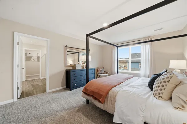 a bedroom with a large bed and a dresser