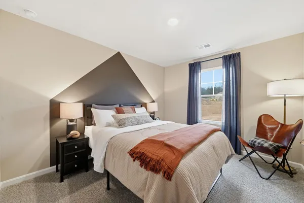 a bedroom with a bed and chair