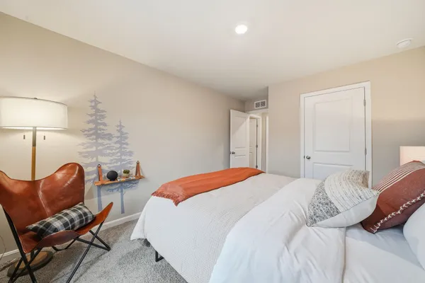 a bedroom with a bed and a lamp