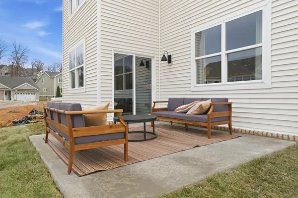 a view of a white house with a bench and a lounge chair