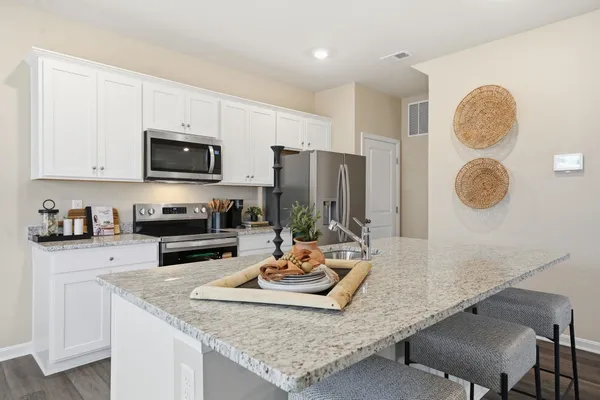 a kitchen with kitchen island granite countertop a sink appliances and cabinets