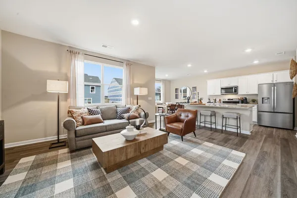 a living room with lots of furniture and kitchen view