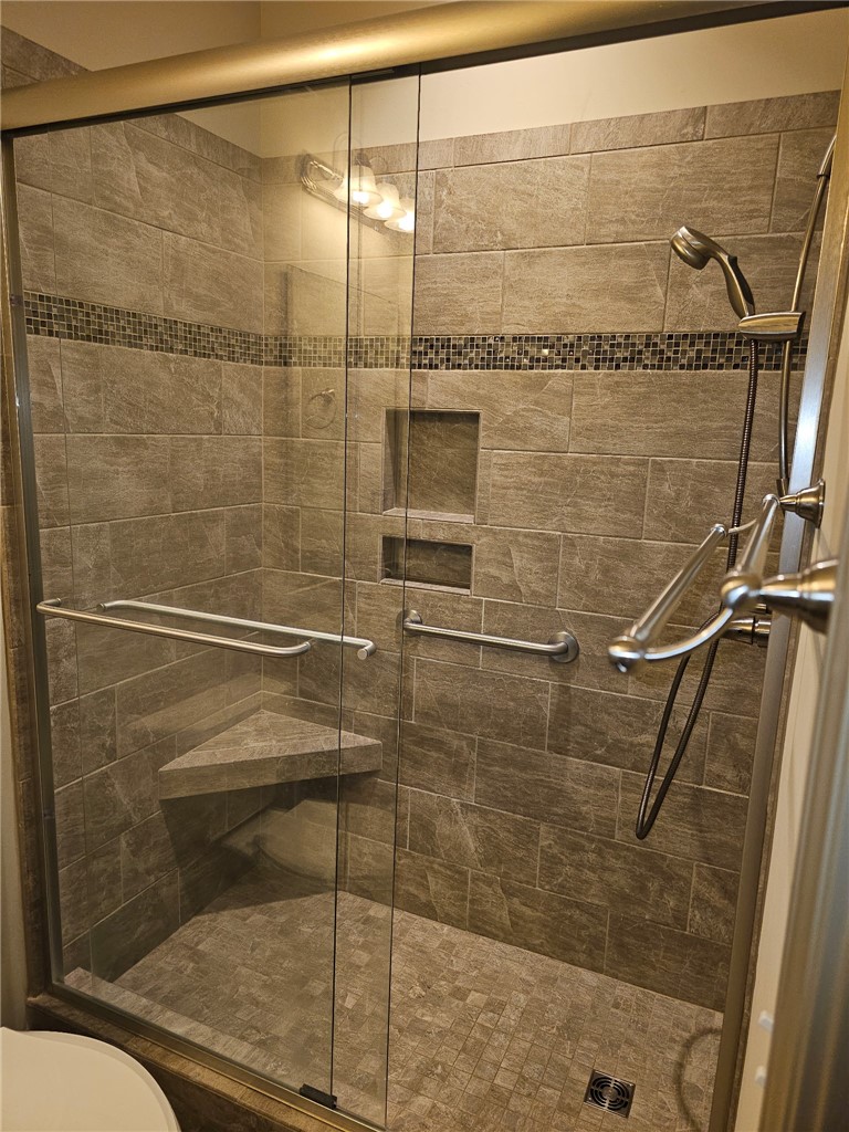 This modern shower features elegant tile work and practical built-in seating for comfort.