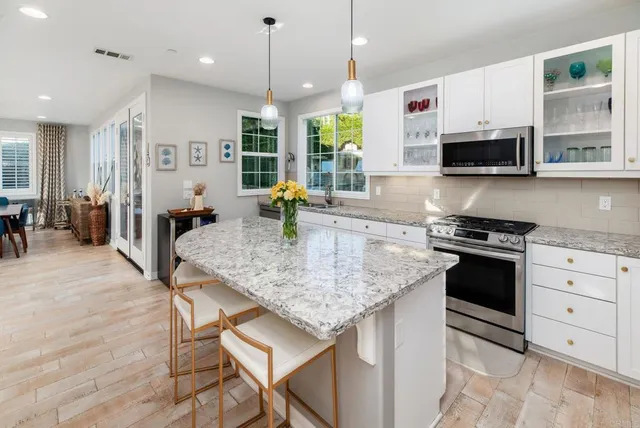 a kitchen with stainless steel appliances granite countertop a sink a stove and a refrigerator