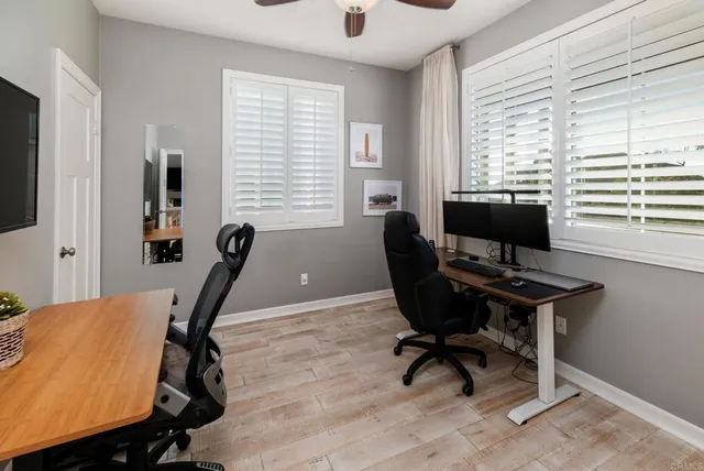 a view of a workspace with furniture and a window