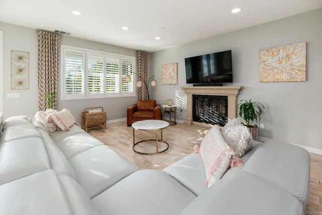 a living room with furniture a fireplace and a flat screen tv