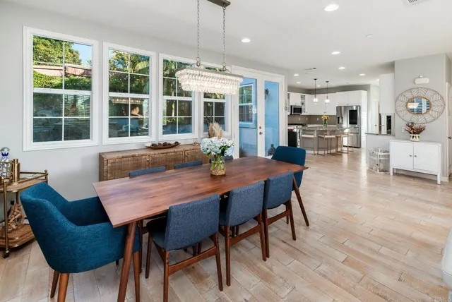 a dining room with furniture a chandelier and wooden floor