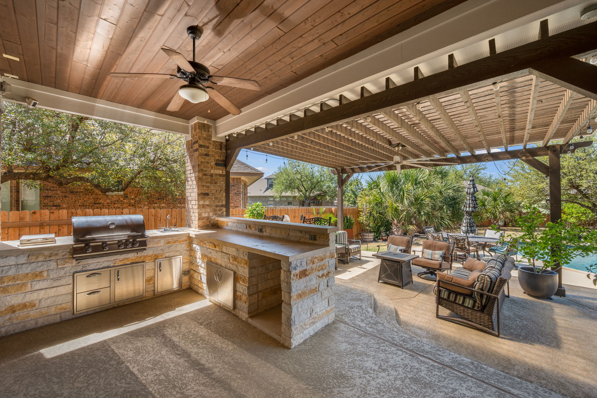 4118 Capora Way Round Rock, TX 78681 - Photo 32 of 39 a open kitchen with stainless steel appliances granite countertop a barbecue grill and couches with wooden floor