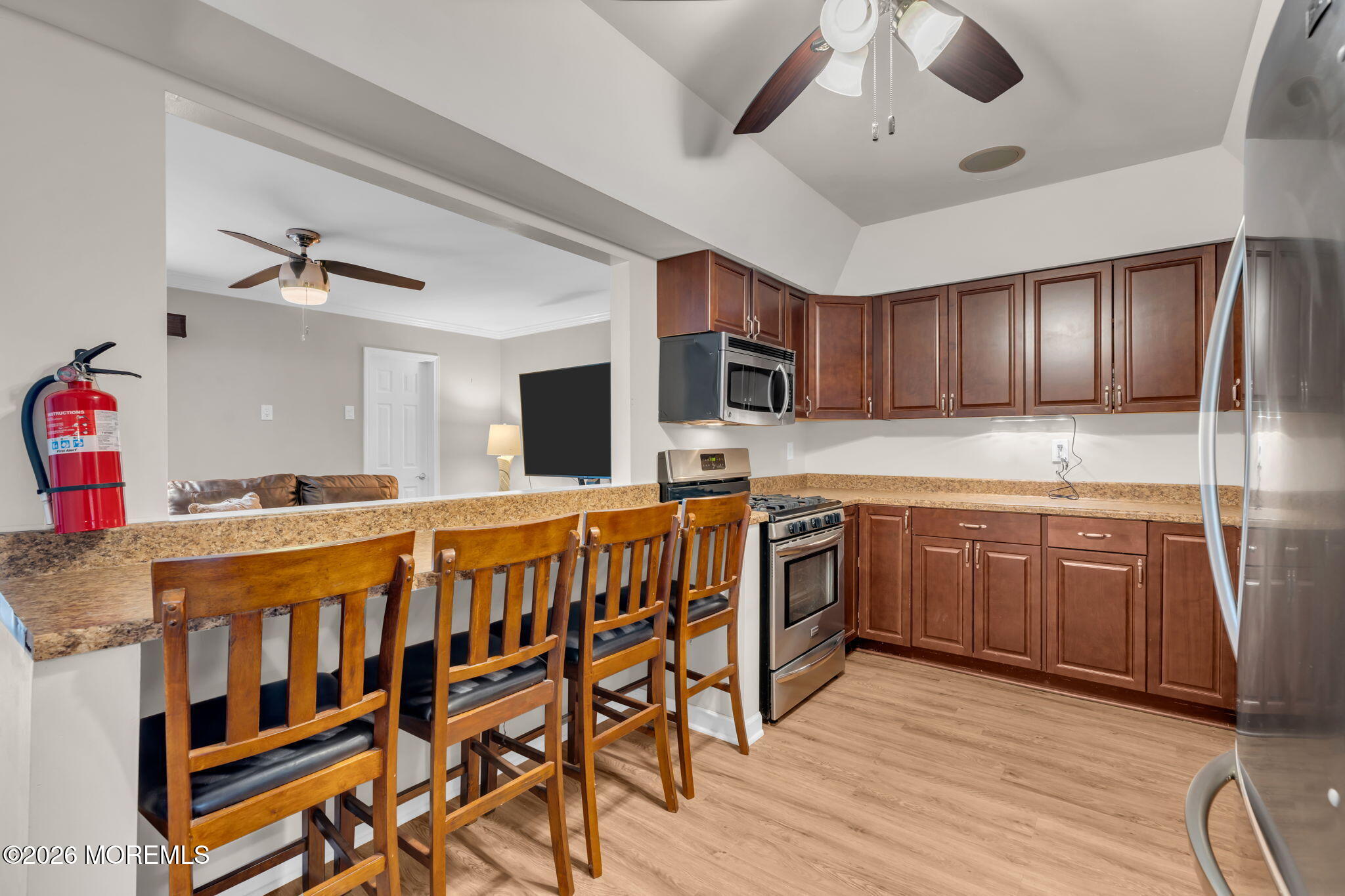 72 Kingsley Way Freehold, NJ 07728 - Photo 13 of 36 a kitchen with stainless steel appliances kitchen island granite countertop a table chairs in it and wooden floors