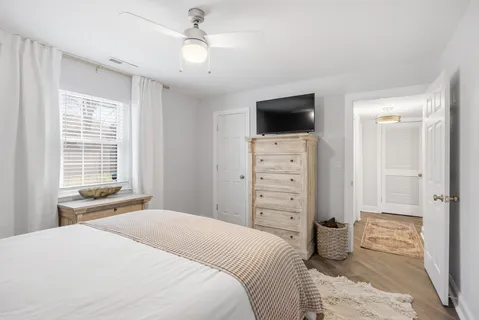 a bedroom with a bed a window and a television