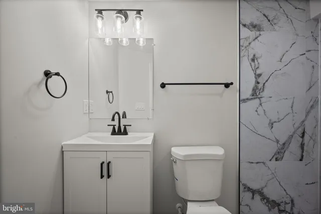 a bathroom with a sink a toilet and a mirror