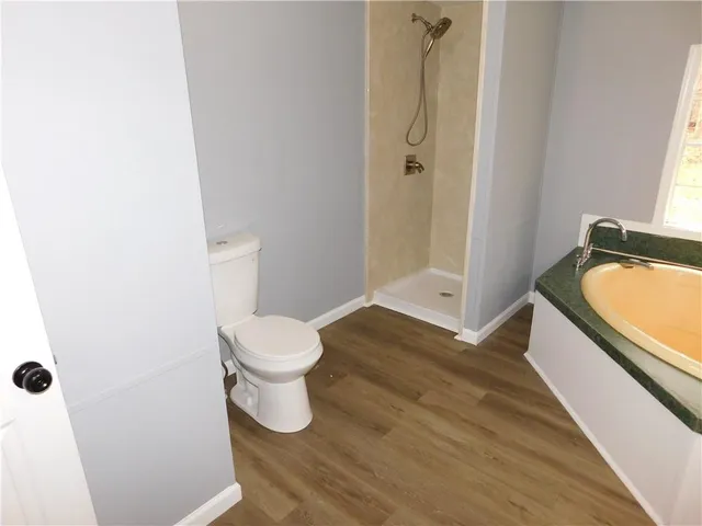 a bathroom with a granite countertop toilet and a sink
