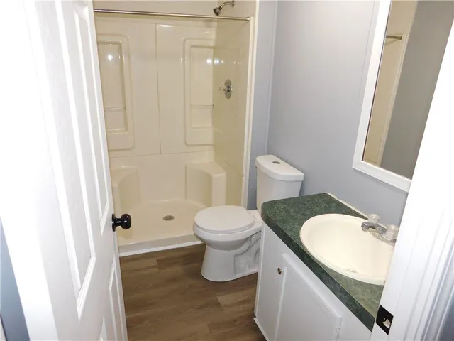 a bathroom with a granite countertop toilet and a sink
