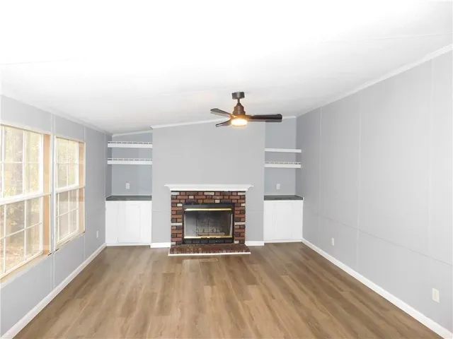 a view of empty room with wooden floor and fireplace