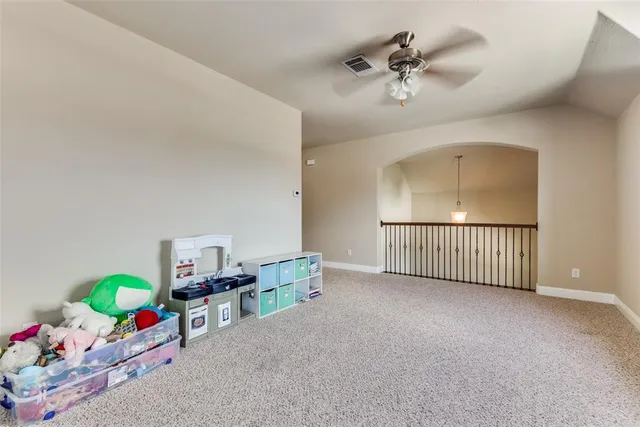 a view of room with toys and a ceiling fan
