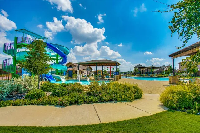 a view of a house with a yard and potted plants