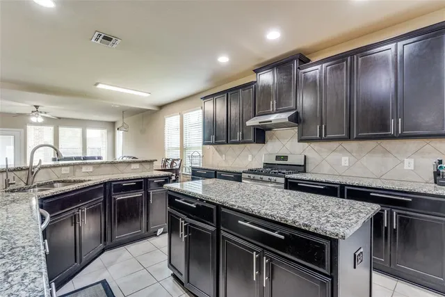 a kitchen with a stove sink and cabinets