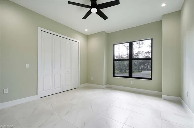 an empty room with windows and fan