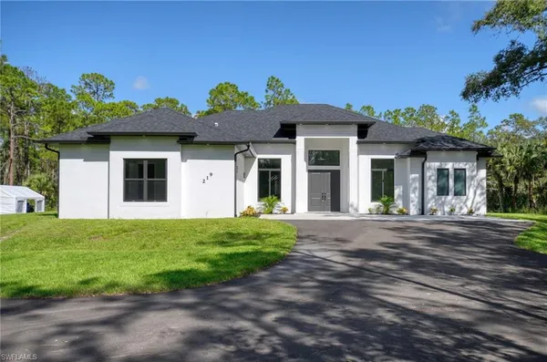 a front view of a house with a garden
