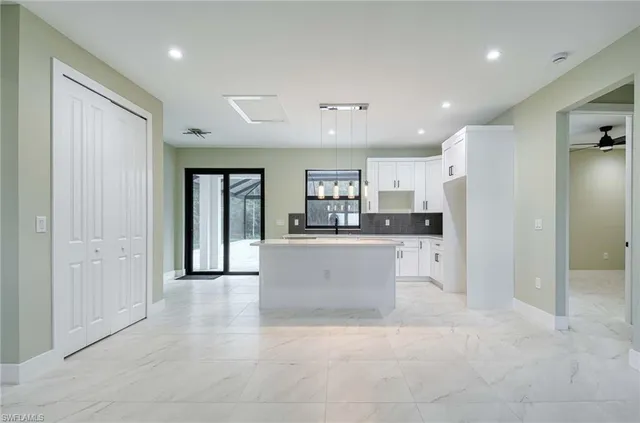 a view of kitchen with refrigerator and windows