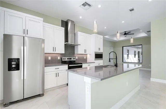 a kitchen with stainless steel appliances granite countertop a refrigerator and a stove